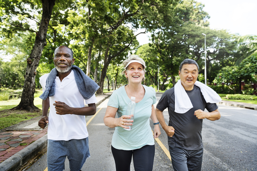Group of senior friends jogging together in a park